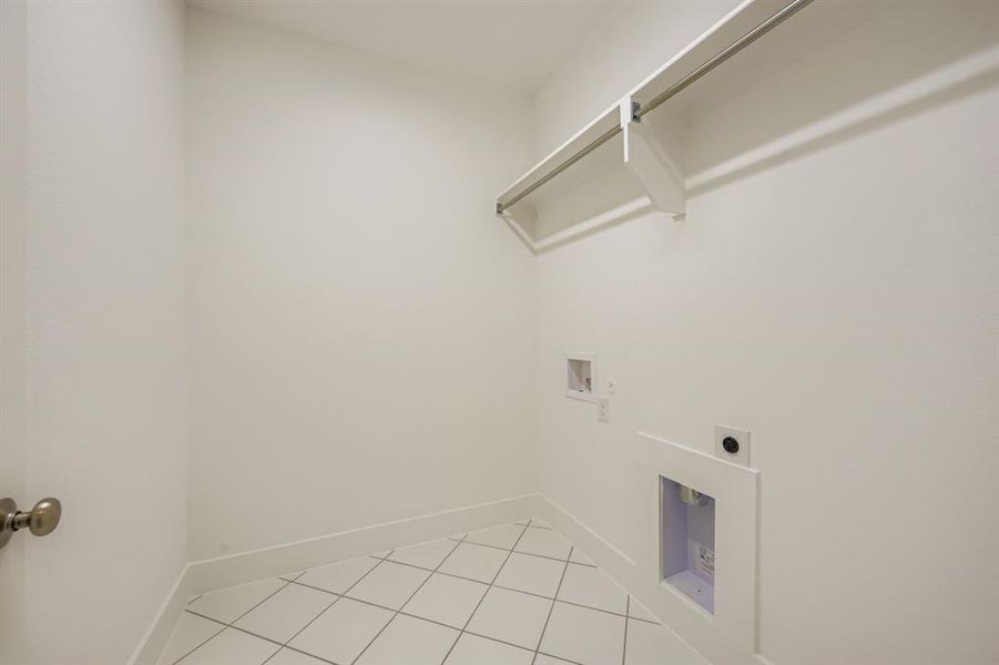 Laundry room featuring light tile patterned flooring, hookup for a washing machine, and hookup for an electric dryer Laundry room featuring light tile patterned flooring, hookup for a washing machine, and hookup for an electric dryer