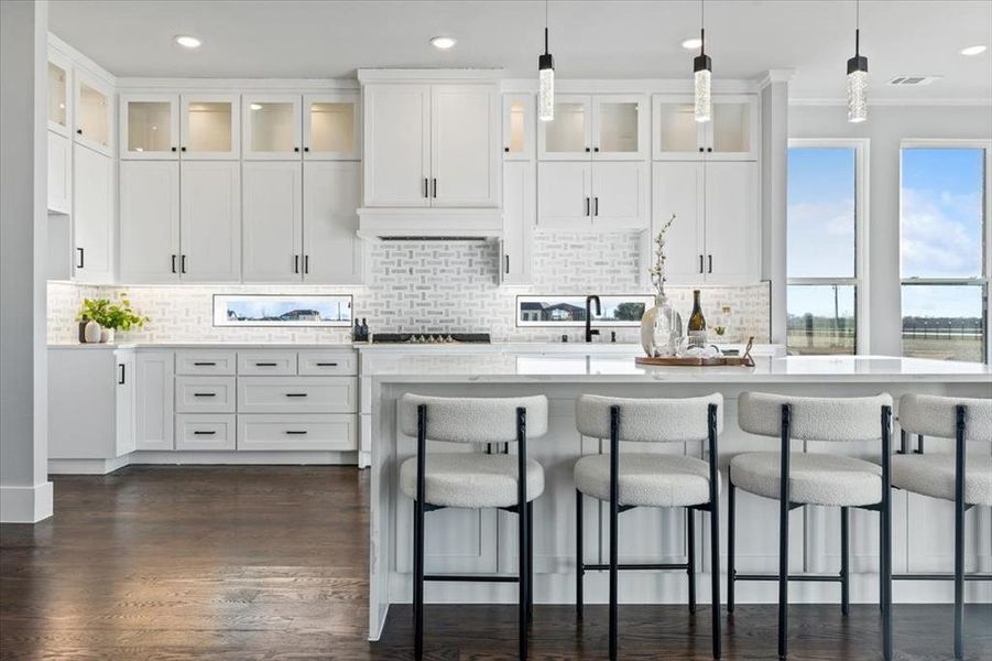 Kitchen featuring crown molding, a kitchen island with sink, hanging light fixtures, white cabinets, and dark hardwood / wood-style flooring