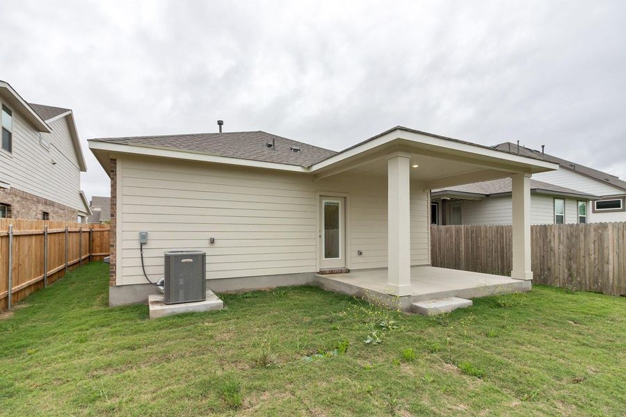 The property features a covered patio with pillars, a door with a glass pane, and a fenced yard