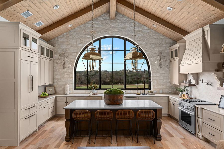 Kitchen with glass insert cabinets, a breakfast bar area, a center island, hanging light fixtures, and a wooden ceiling with exposed beams