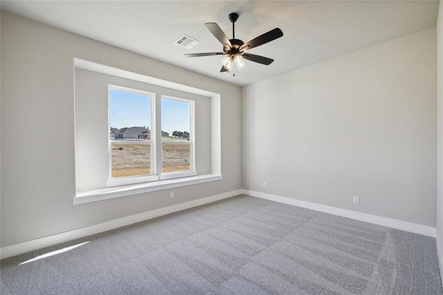 Empty room featuring light carpet and ceiling fan