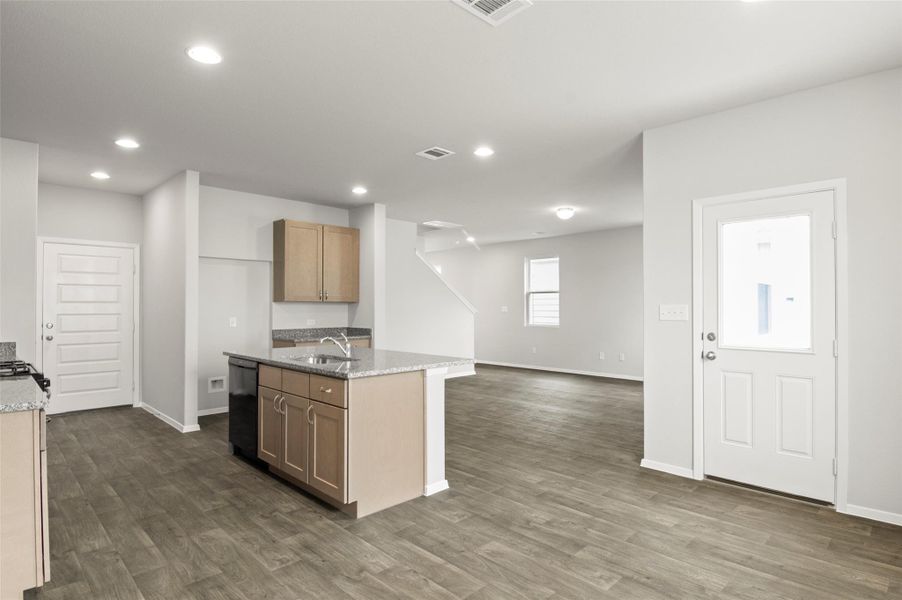 Kitchen featuring a sink, baseboards, dark wood finished floors, light stone counters, and dishwasher