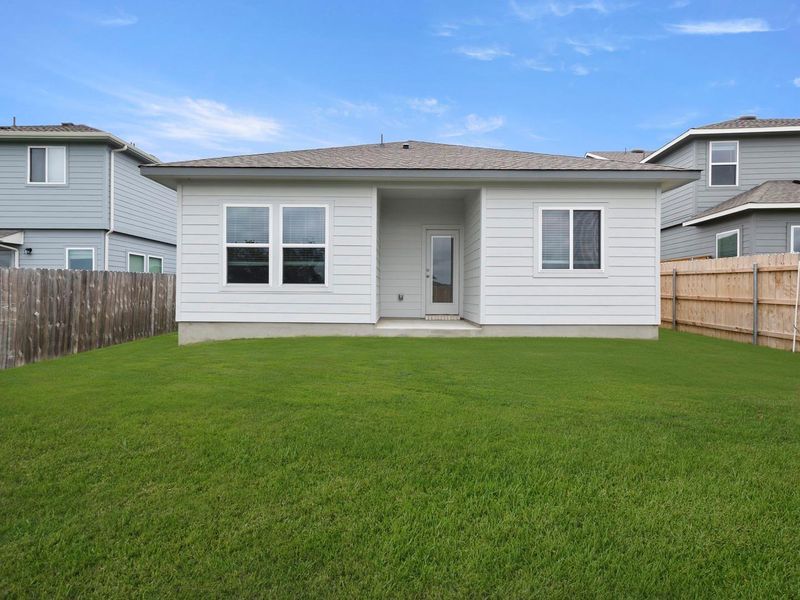 A spacious, verdant yard invites outdoor activities, complete with a private wooden fence.
