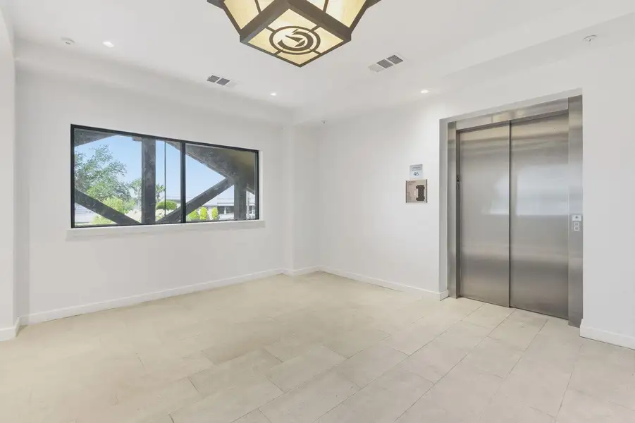 Unfurnished room with elevator and recessed lighting