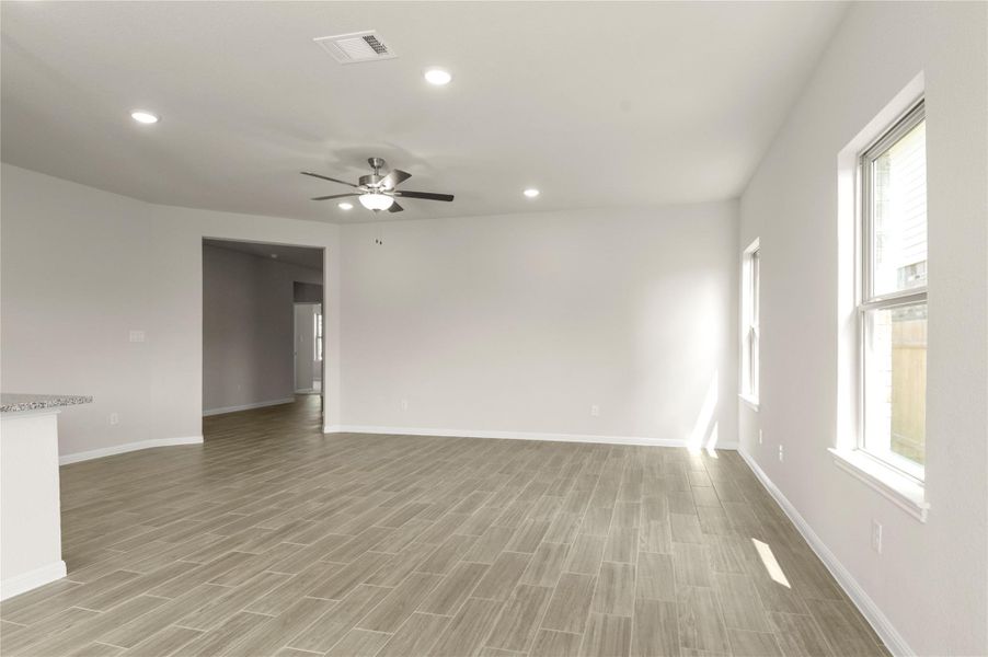 Empty room featuring a ceiling fan, light wood-style floors, and recessed lighting