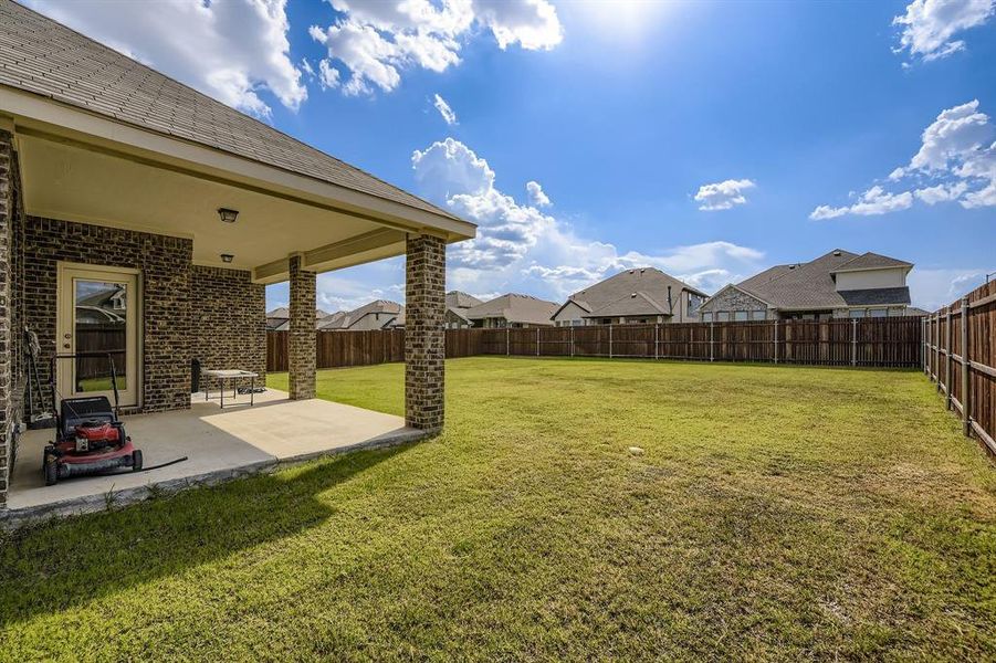 Fenced backyard with a patio area and a residential view Fenced backyard with a patio area and a residential view