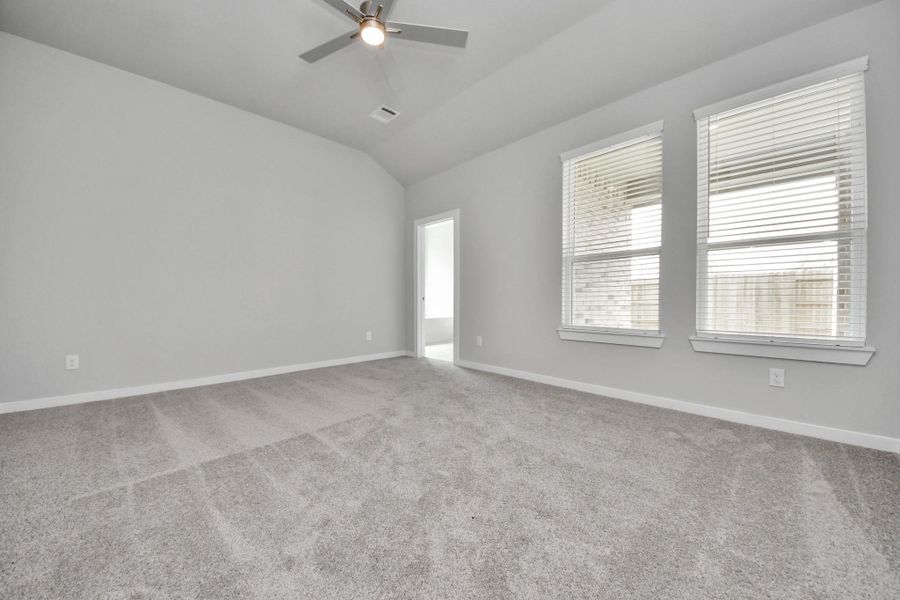 Come and unwind after a long day in this magnificent primary suite! This spacious room features plush carpet, warm paint, high ceilings and large windows with privacy blinds. Sample photo of completed home with similar floor plan. Actual colors and selections may vary.