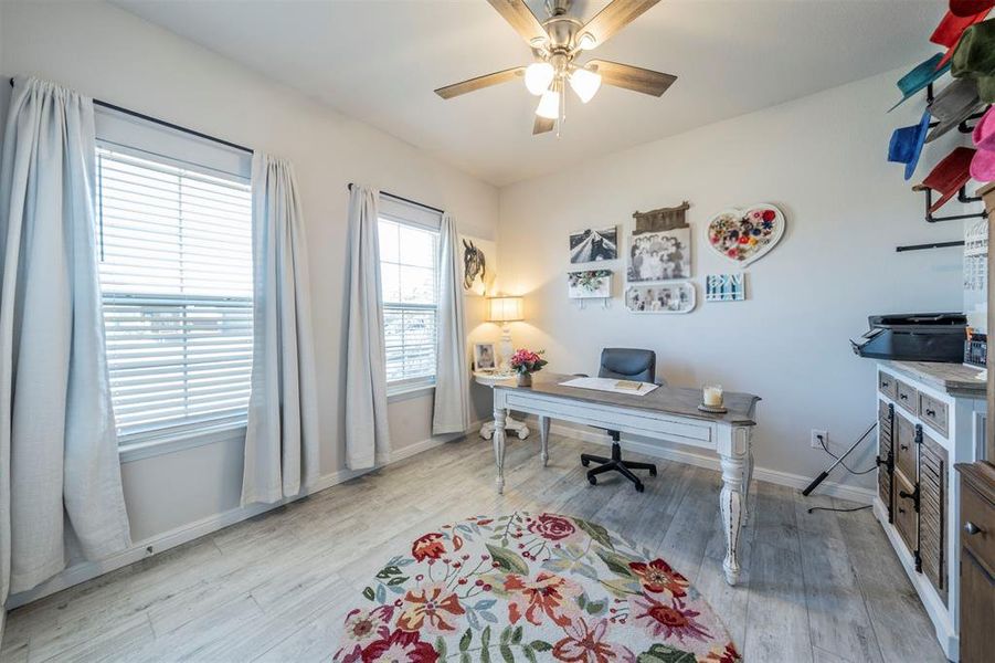 Home office featuring ceiling fan and light hardwood / wood-style flooring