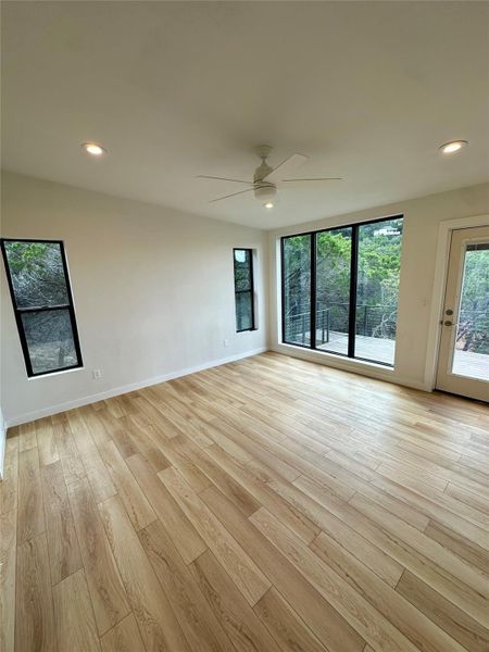 Empty room featuring plenty of natural light, recessed lighting, light wood-type flooring, and a ceiling fan Empty room featuring plenty of natural light, recessed lighting, light wood-type flooring, and a ceiling fan