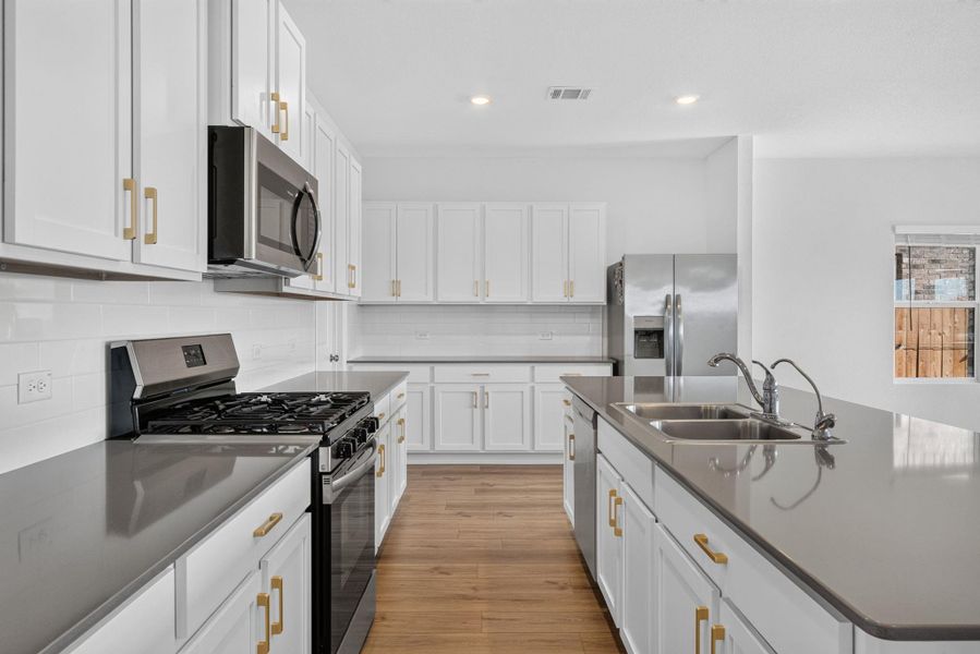 A well-appointed culinary space featuring sleek cabinetry, modern appliances, and generous counter space. A well-appointed culinary space featuring sleek cabinetry, modern appliances, and generous counter space.