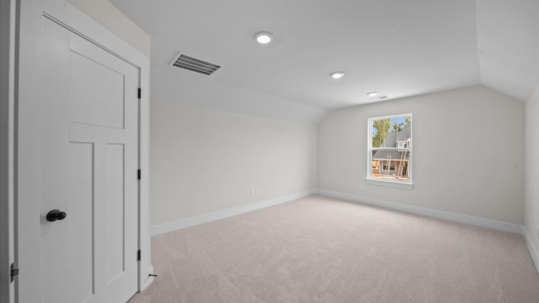 Elegant bedroom retreat featuring soft carpet and oversized windows that create a bright, welcoming space