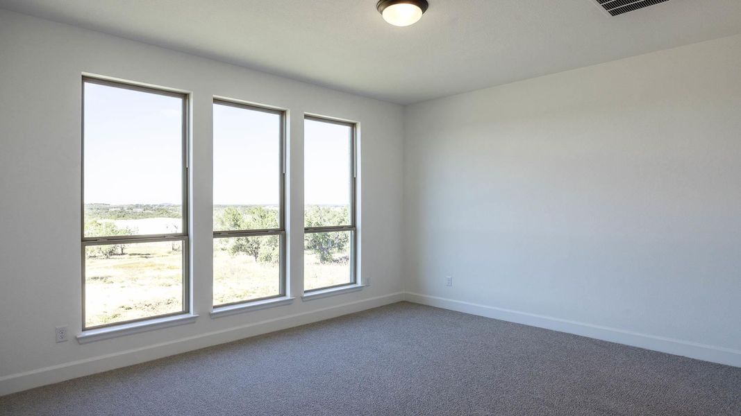 Carpeted spare room featuring baseboards