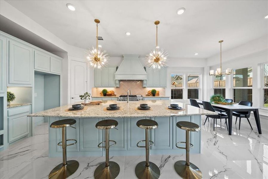 Kitchen featuring a spacious island, quartz counters, light marble floors, a breakfast bar area, and recessed lighting Kitchen featuring a spacious island, quartz counters, light marble floors, a breakfast bar area, and recessed lighting