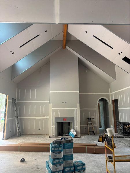 Construction progress highlighting the main living area, showcasing floor-to-ceiling fireplace that defines the space with architectural elegance.