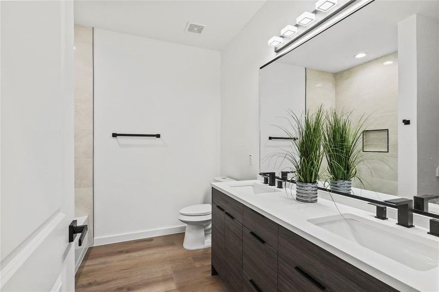 Bathroom with wood-type flooring, vanity, and toilet