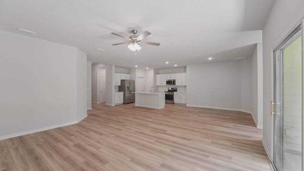 Elegant wood flooring and quartz-topped kitchen island exude luxury in Palm Coast's premier residence.