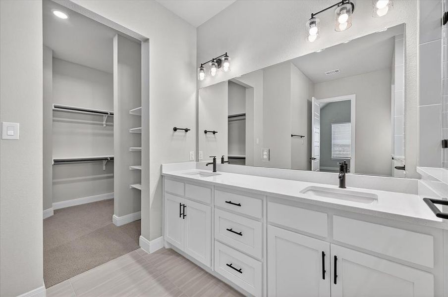 Bathroom featuring a dual vanity with white cabinetry, black hardware, and integrated rectangular sinks Bathroom featuring a dual vanity with white cabinetry, black hardware, and integrated rectangular sinks