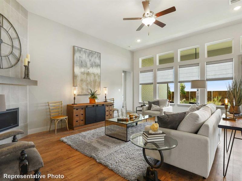 Living area with wood finished floors, recessed lighting, a tile fireplace, and a ceiling fan Living area with wood finished floors, recessed lighting, a tile fireplace, and a ceiling fan