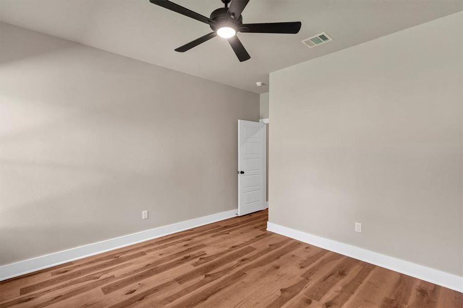 Spare room featuring wood finished floors and ceiling fan Spare room featuring wood finished floors and ceiling fan