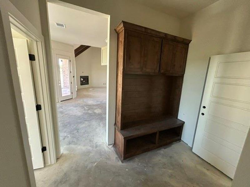 Built-in wooden cabinetry with upper storage and an integrated bench