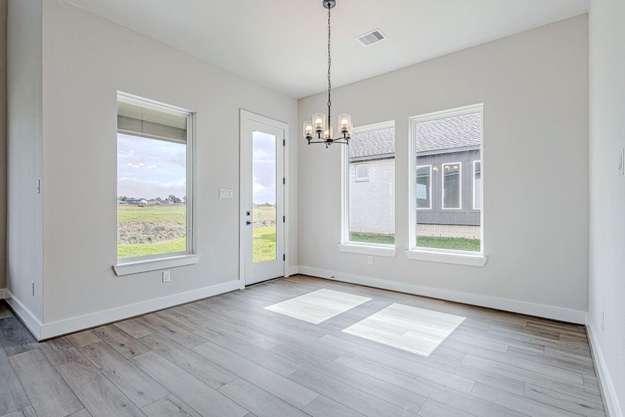Dining area filled with natural light, offering a comfortable space for meals and hosting.