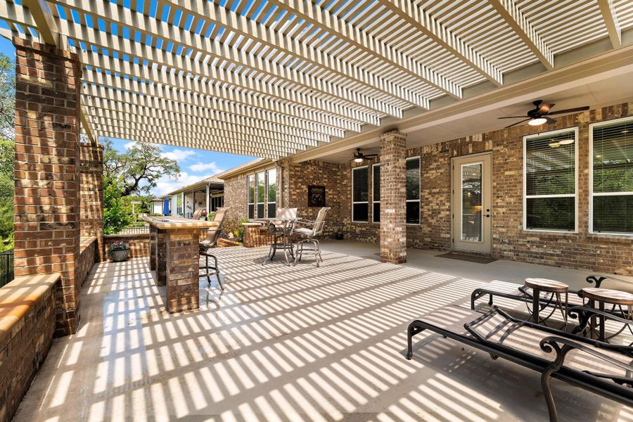 An inviting covered patio, ideal for outdoor entertaining, features ample space and a pergola providing dappled sunlight. An inviting covered patio, ideal for outdoor entertaining, features ample space and a pergola providing dappled sunlight.