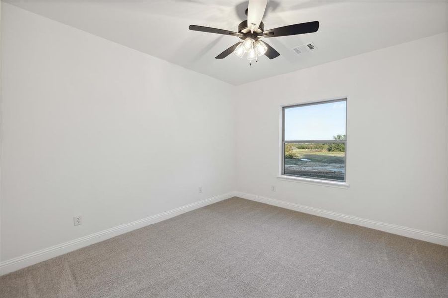 Carpeted empty room with ceiling fan