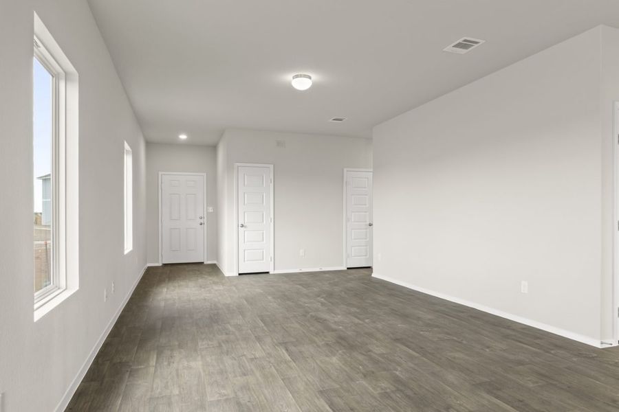 Image of living room with brown flooring and light grey walls and white doors
