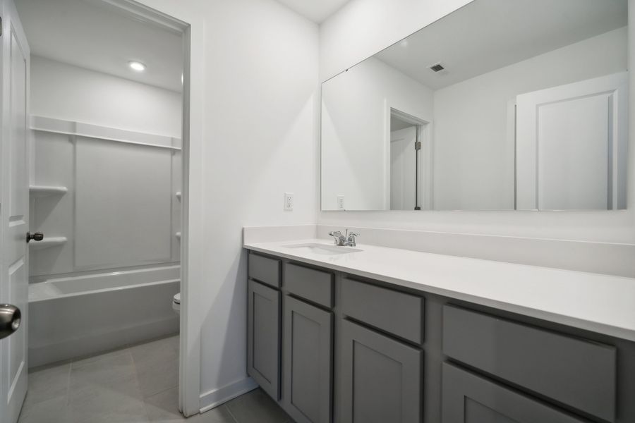 A bathroom with a sink and a shower unit. A bathroom with a sink and a shower unit.