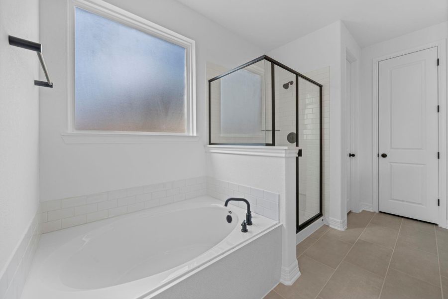 This additional view of your primary bathroom features tile flooring, fresh paint, walk-in shower, a separate garden tub, and a large walk-in closet. This additional view of your primary bathroom features tile flooring, fresh paint, walk-in shower, a separate garden tub, and a large walk-in closet.