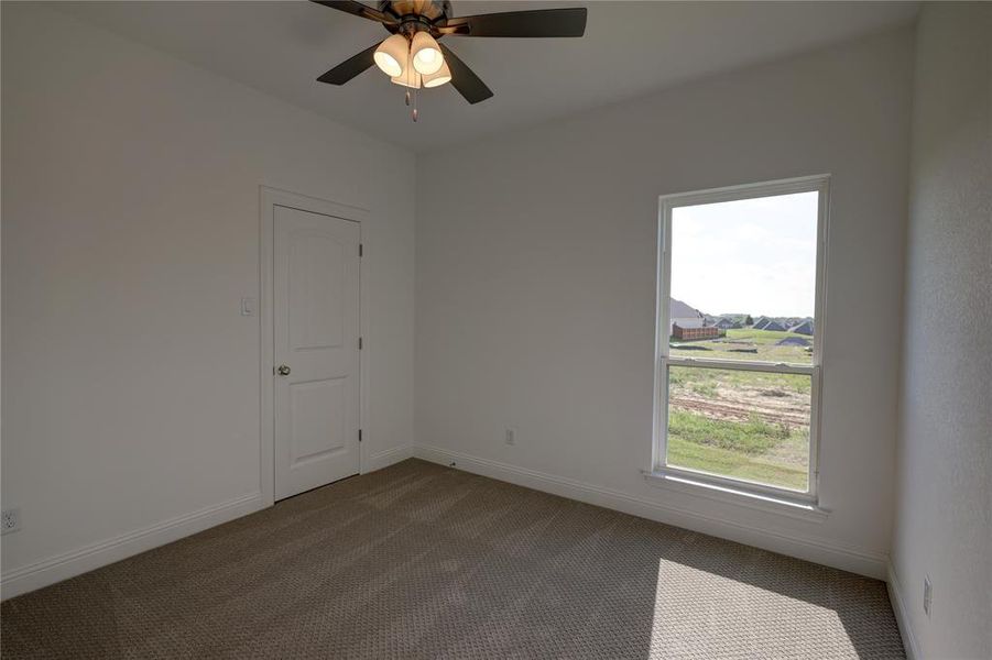 Spare room featuring carpet and a ceiling fan Spare room featuring carpet and a ceiling fan