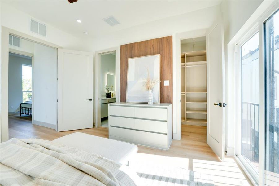 Bedroom with a spacious closet, light wood-type flooring, and a closet