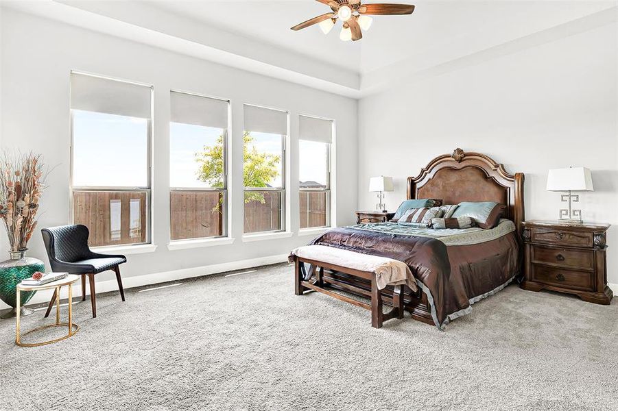 Carpeted bedroom featuring ceiling fan and baseboards