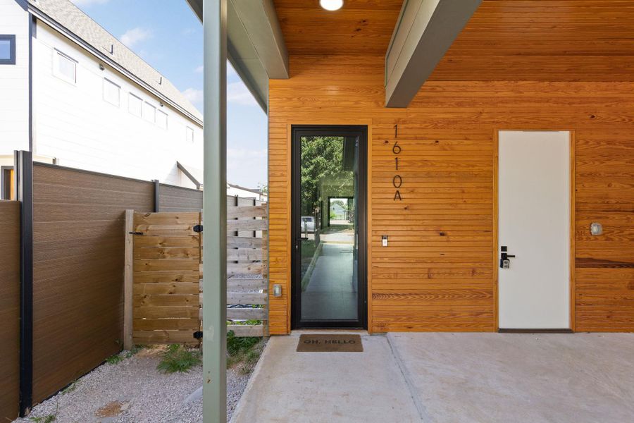 A modern exterior facade features sleek wood siding and a minimalist entryway.