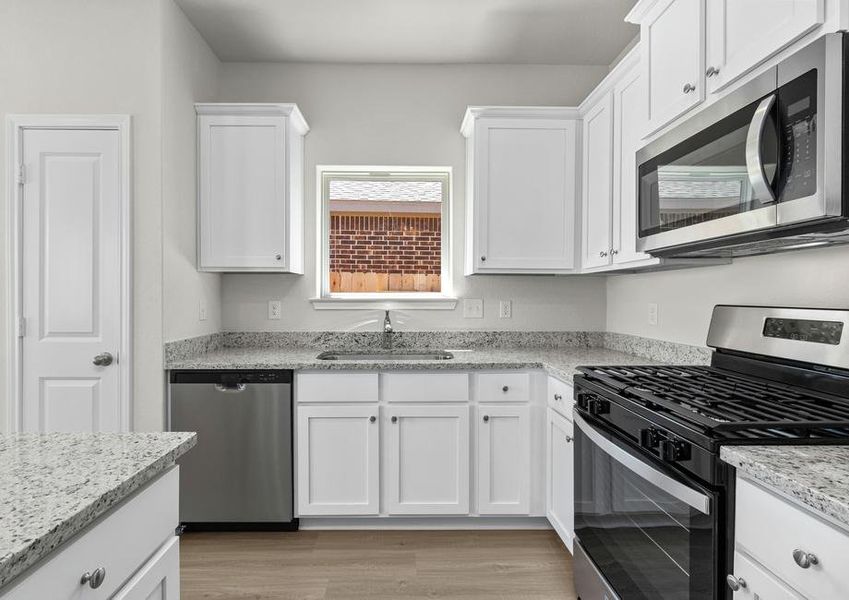 A kitchen with plenty of counterspace and a window over the sink