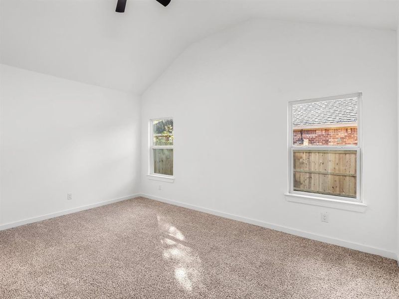 Unfurnished room featuring vaulted ceiling, a ceiling fan, and speckle patterned floor