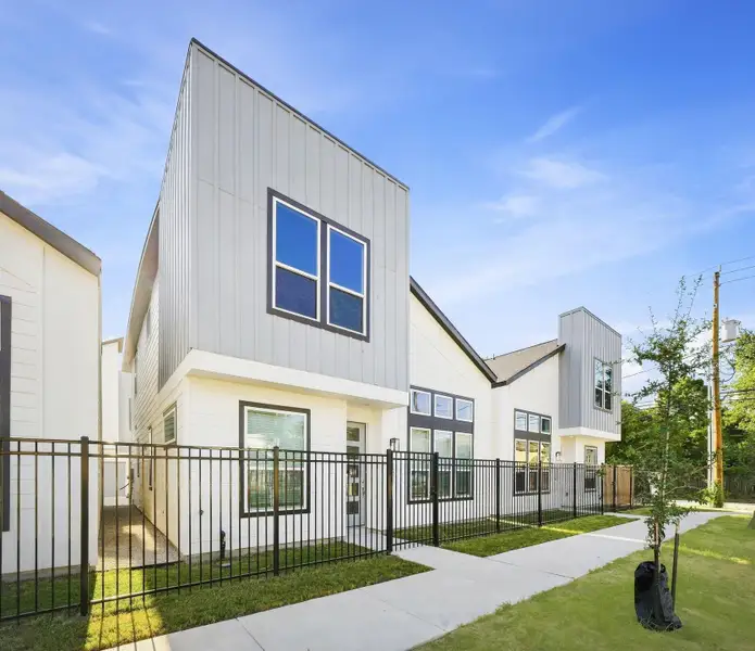 Street-level view showcasing the modern architecture, fenced front yards, sidewalks, and cohesive contemporary design throughout the community. Street-level view showcasing the modern architecture, fenced front yards, sidewalks, and cohesive contemporary design throughout the community.