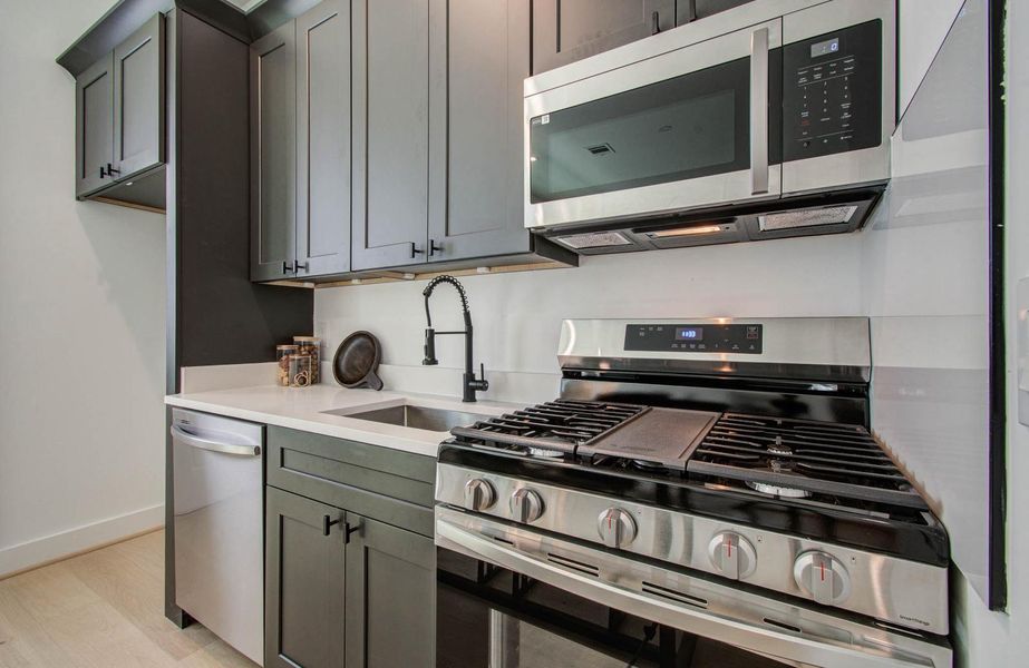 rom left to right: Fridge, Dishwasher, sink, gas stove, vented microwave, stacked washer/dryer rom left to right: Fridge, Dishwasher, sink, gas stove, vented microwave, stacked washer/dryer