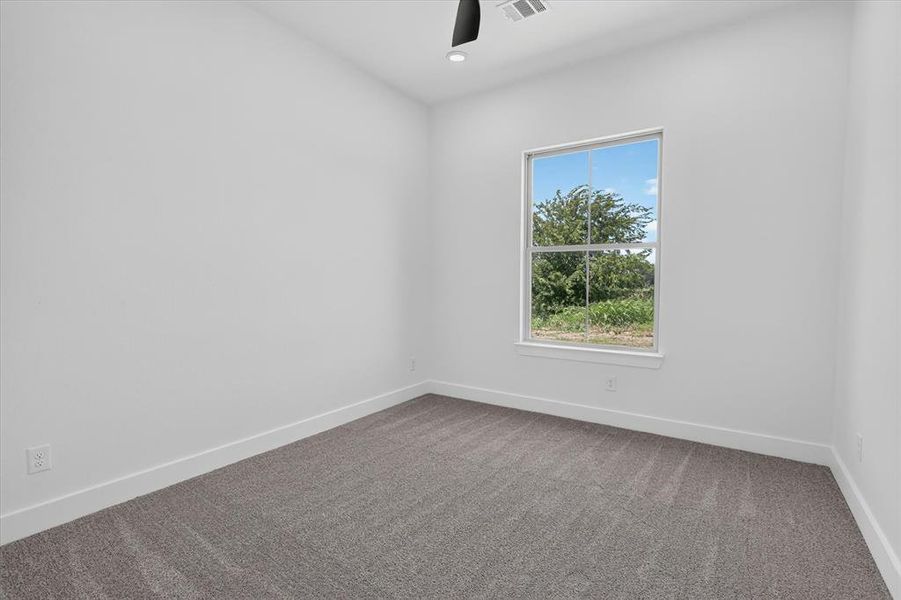 Room with a single-pane window overlooking natural scenery, featuring neutral carpeting and white baseboards