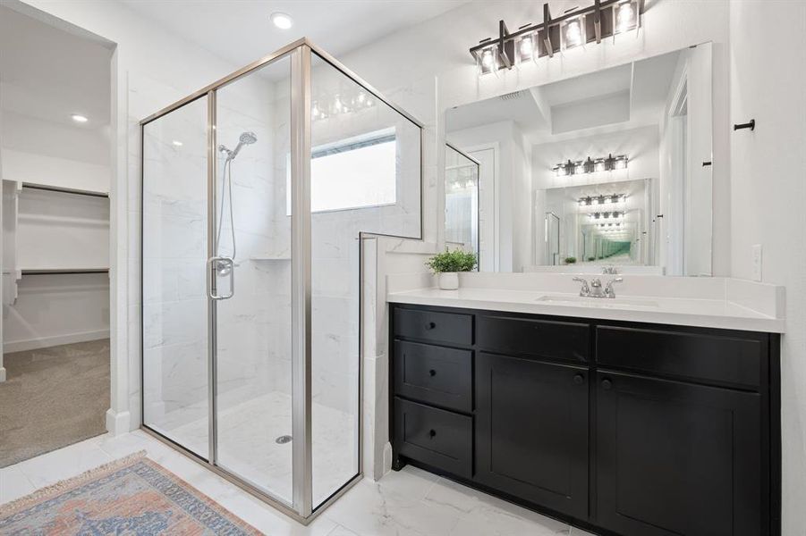 Bathroom featuring a glass-enclosed shower with white tiled walls and a built-in shelf