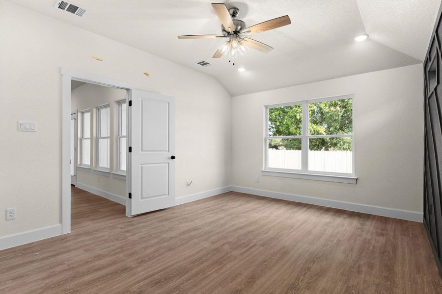 Empty room with vaulted ceiling, light wood finished floors, a ceiling fan, and recessed lighting