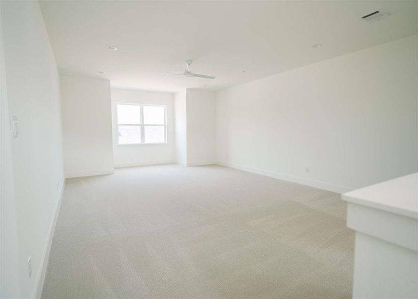 Carpeted empty room featuring ceiling fan