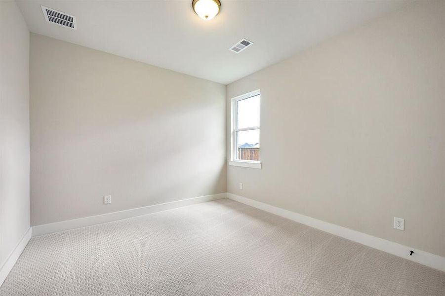 Empty room featuring light carpet and baseboards