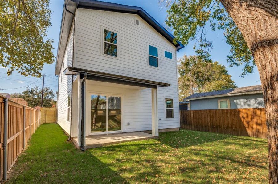 Rear view of house featuring a fenced backyard and a patio area