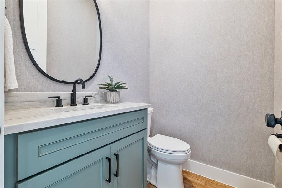 Bathroom featuring hardwood / wood-style floors, oversized vanity, and toilet