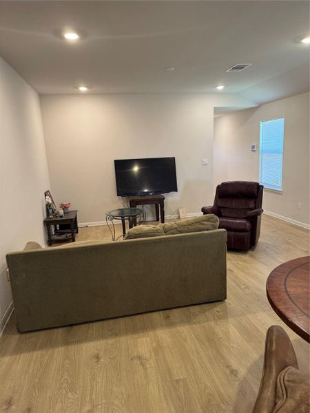 Living area featuring light wood-style flooring and recessed lighting