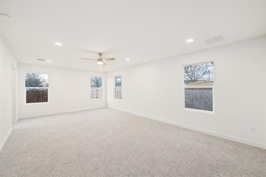 Unfurnished room with recessed lighting, visible vents, plenty of natural light, and carpet flooring