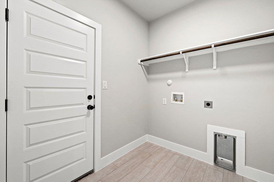 Washroom with hookup for an electric dryer, washer hookup, light wood-type flooring, baseboards, and hookup for a gas dryer Washroom with hookup for an electric dryer, washer hookup, light wood-type flooring, baseboards, and hookup for a gas dryer