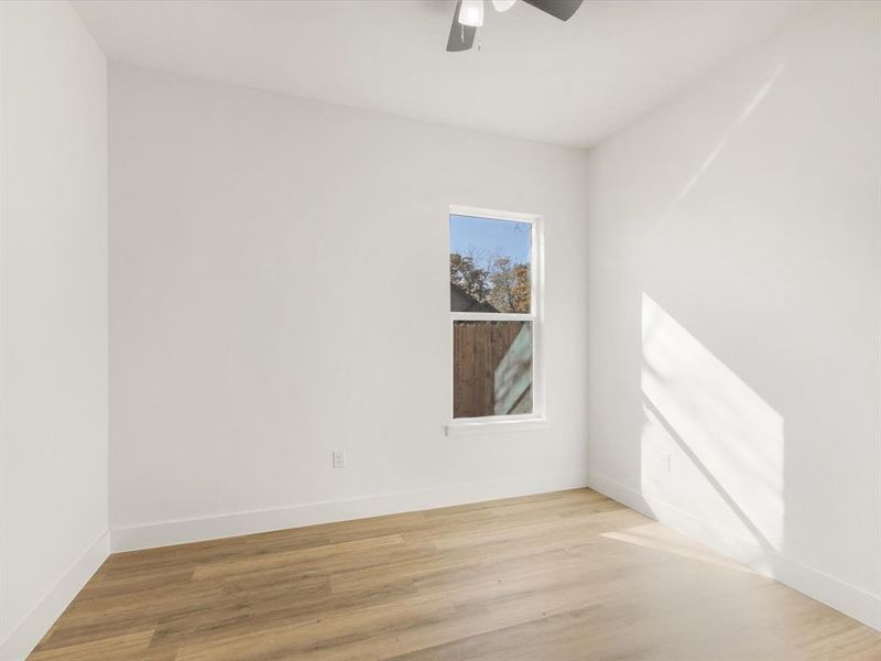 Empty room with light wood-type flooring and ceiling fan