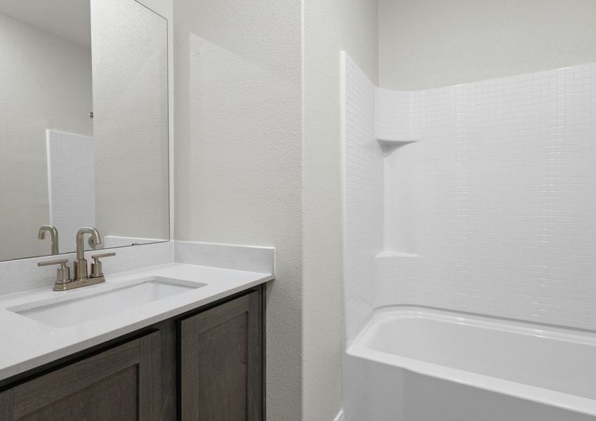 The secondary bathroom has a sprawling vanity and shower-tub combo.